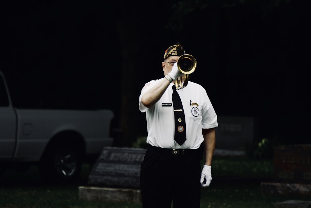 man standing and blowing trumpet