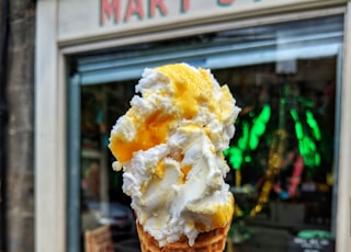 person holding mango and vanilla ice cream