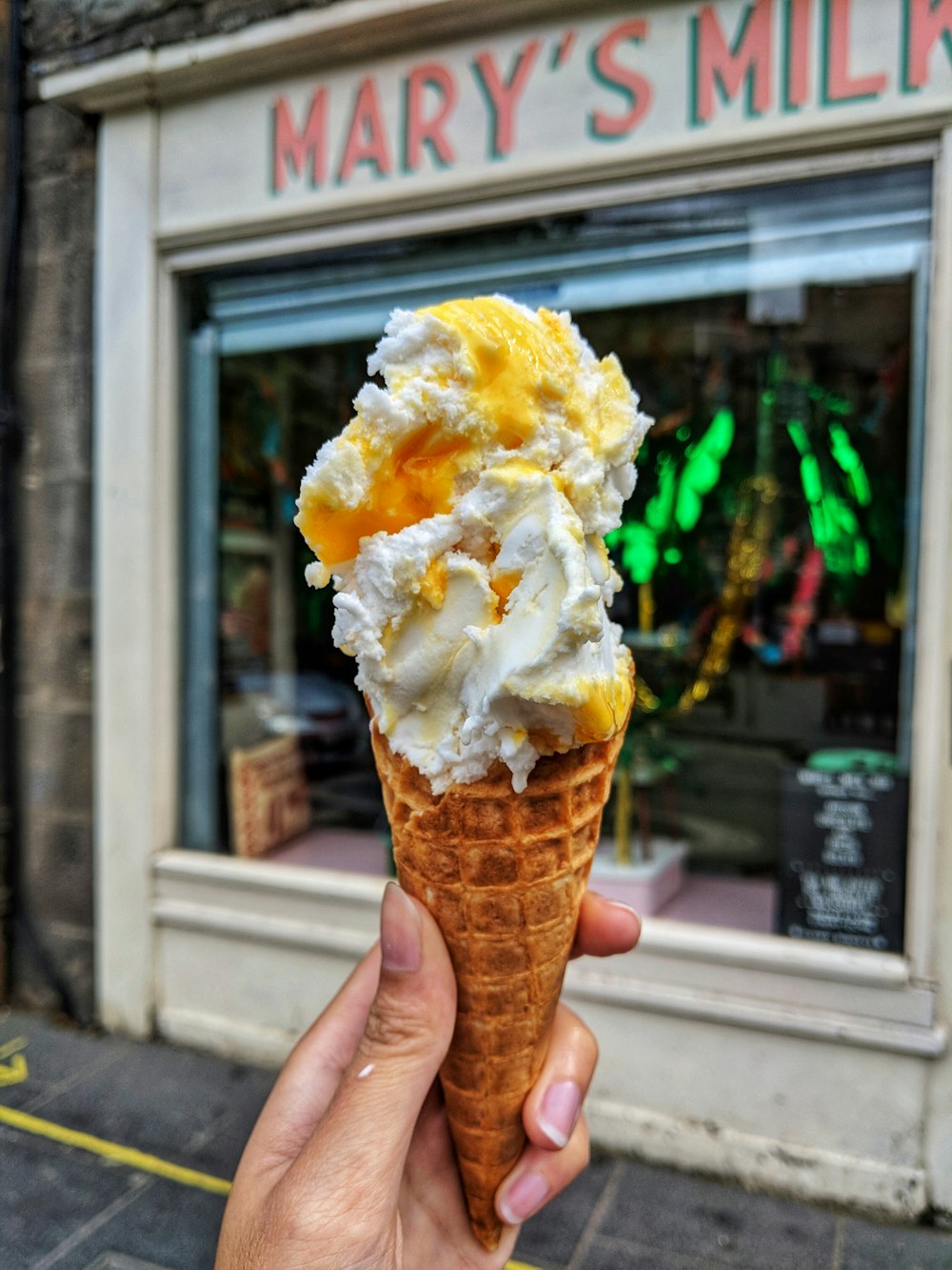 person holding mango and vanilla ice cream