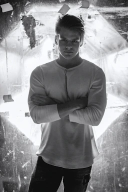 A close-up of a man wearing a soft, breathable premium t-shirt in a modern fit, standing confidently against a clean white background.