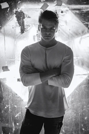 A close-up shot of a man wearing a sleek black shirt from eled trade, standing confidently in soft natural light.