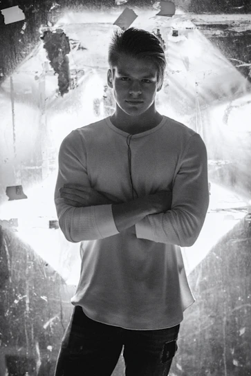 Close-up of a stylish man wearing a crisp white shirt against a minimalist white background.