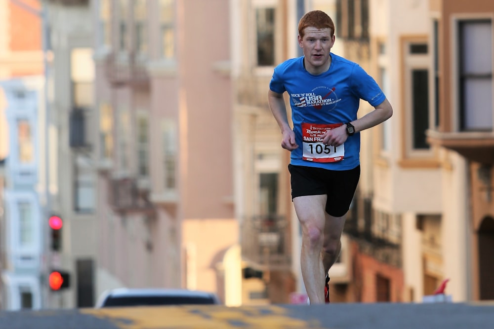 man running on street surrounded with building