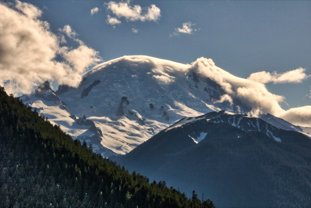 a mountain covered in snow under a cloudy sky, Mt. Rainier