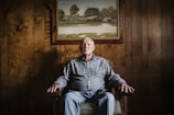 man sitting on armchair beside photo frame