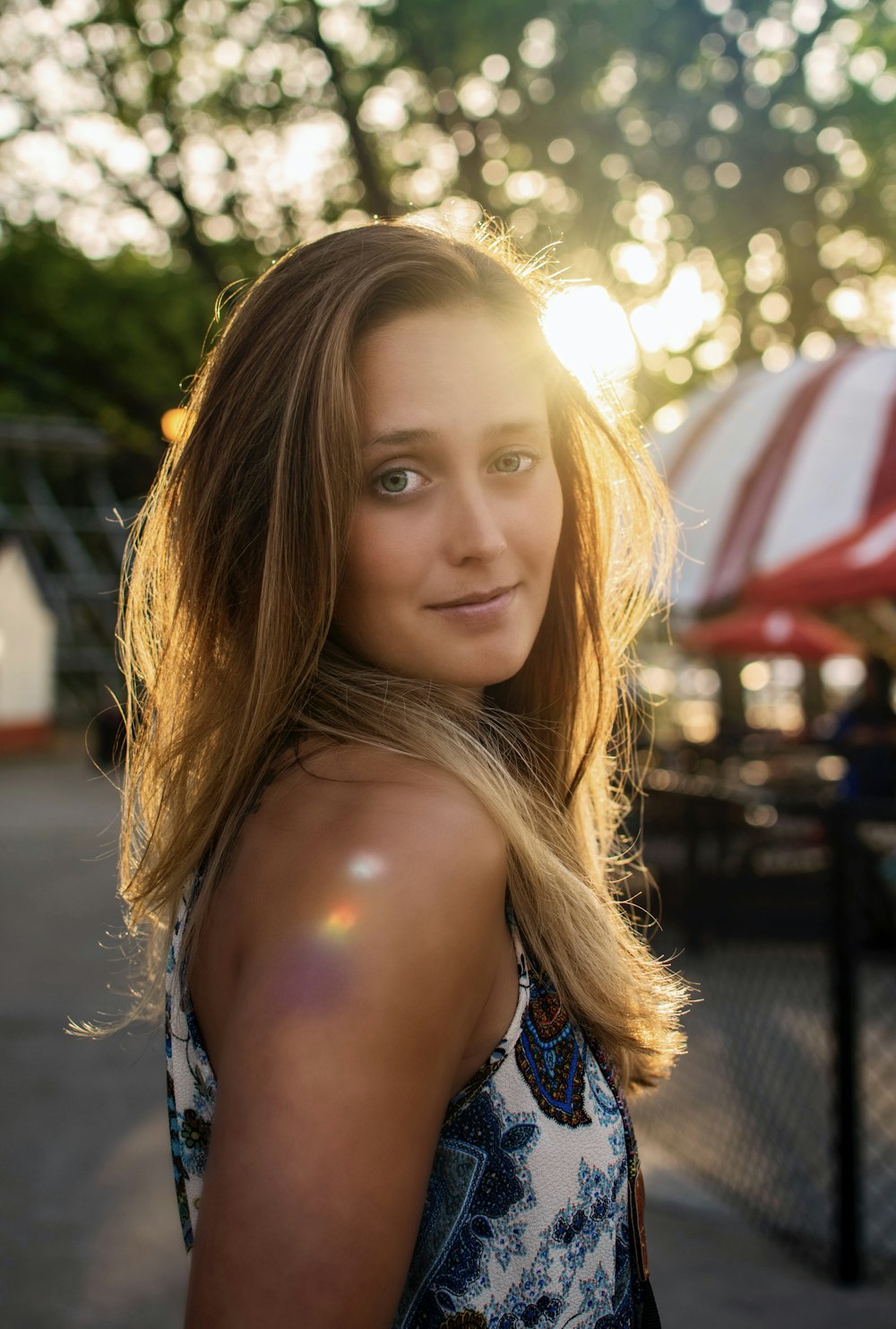 selective focus photography of woman standing near black fence at day time