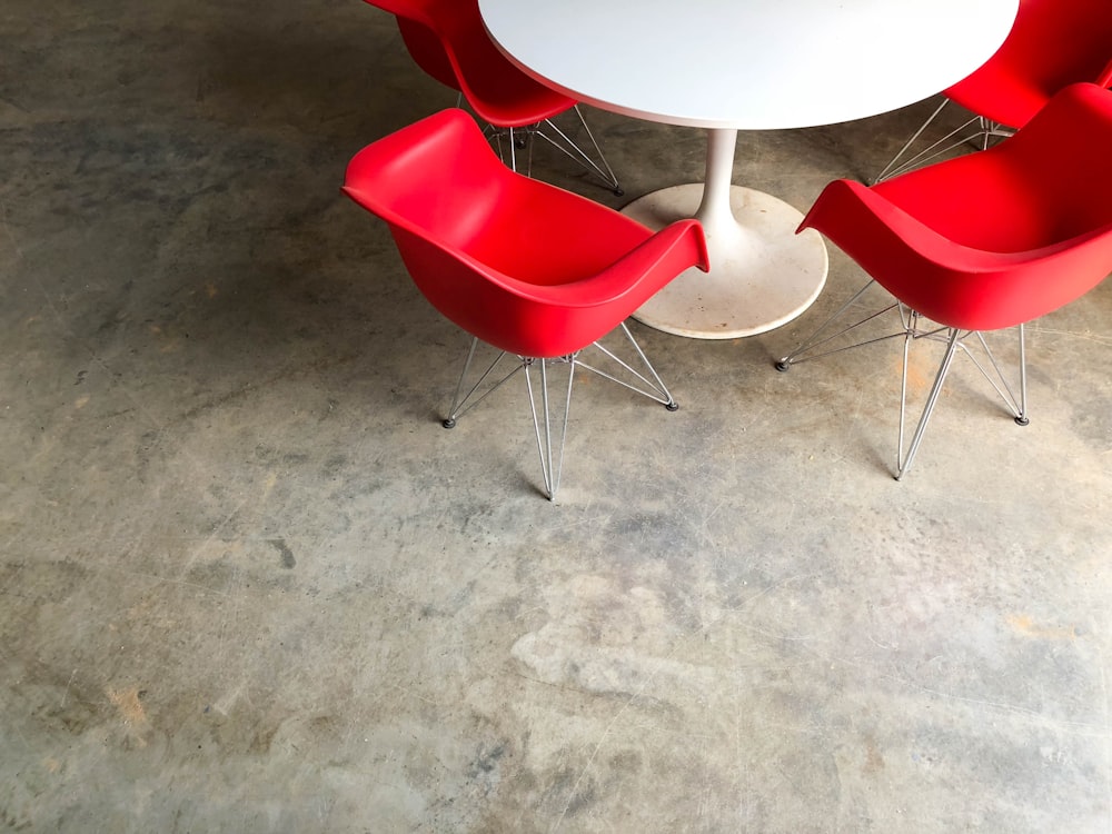 red plastic chairs near white pedestal table