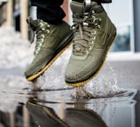 person wearing green Nike sneakers jumping on water