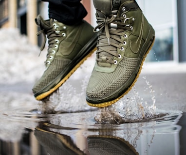 person wearing green Nike sneakers jumping on water