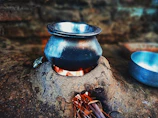 Traditional mitti ka chulha with litti roasting over glowing embers.