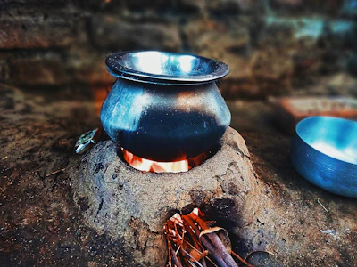 Traditional mitti ka chulha with litti roasting over glowing embers.