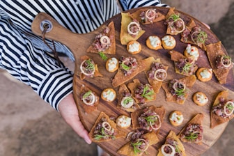assorted chips with vegetable on brown wooden chopping board