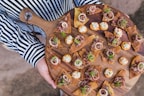 assorted chips with vegetable on brown wooden chopping board