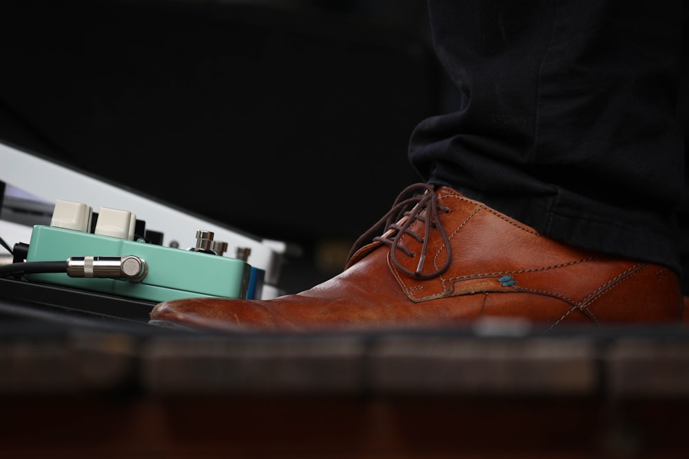 person wearing brown leather lace-up dress shoe