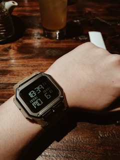 Close-up of the sipro bottle’s digital time and temperature display on a wooden desk beside workout gear.