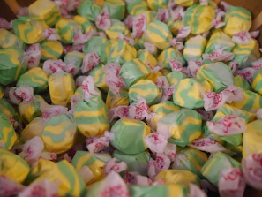 Brightly colored tamarind candies wrapped in shiny paper, scattered on a festive cloth