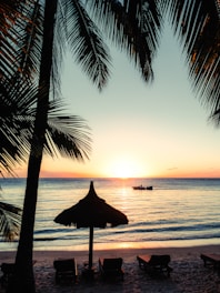 silhouette photo of boat near outdoor loungers