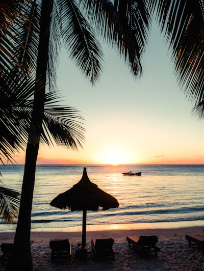 silhouette photo of boat near outdoor loungers