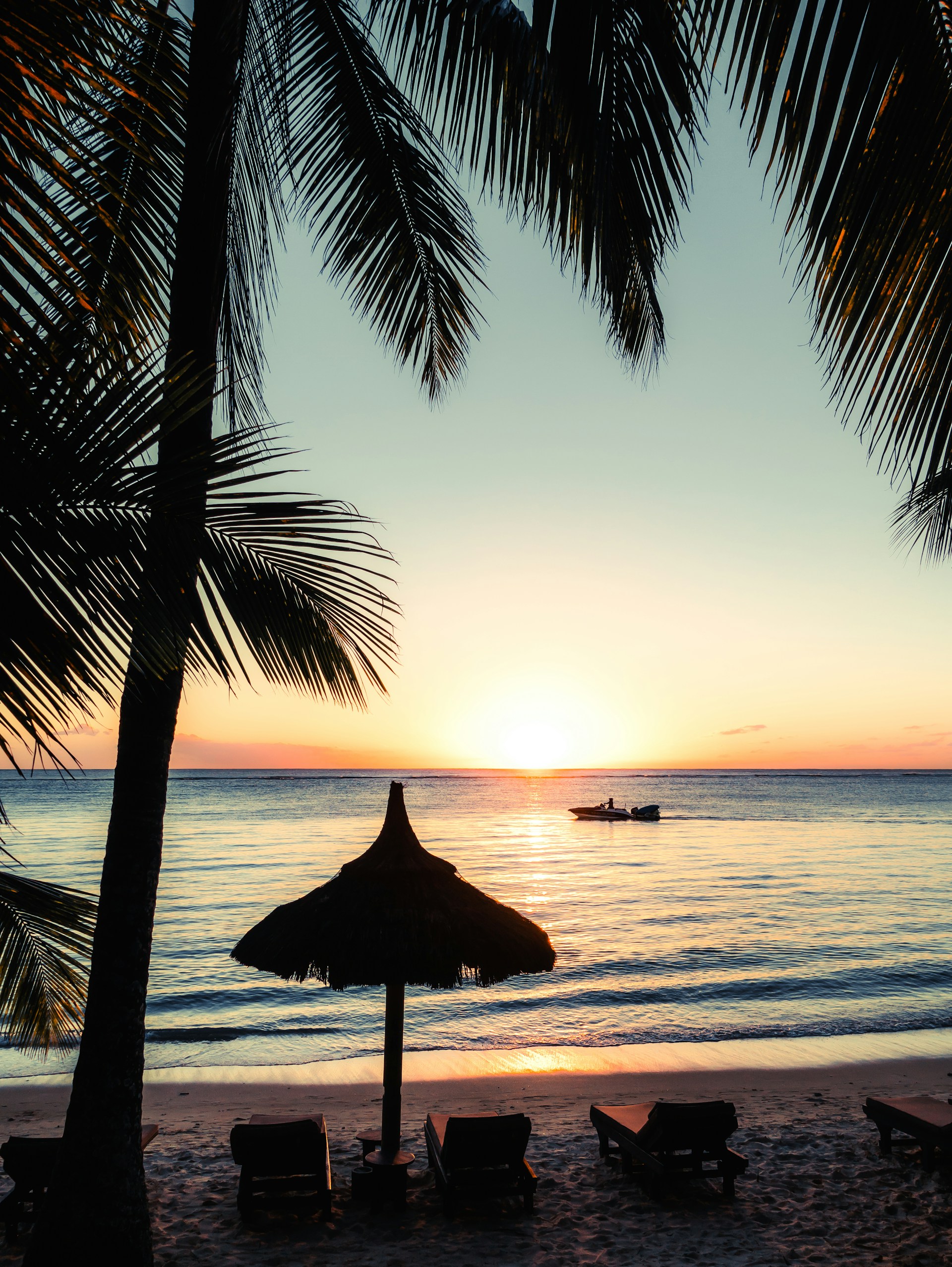 silhouette photo of boat near outdoor loungers