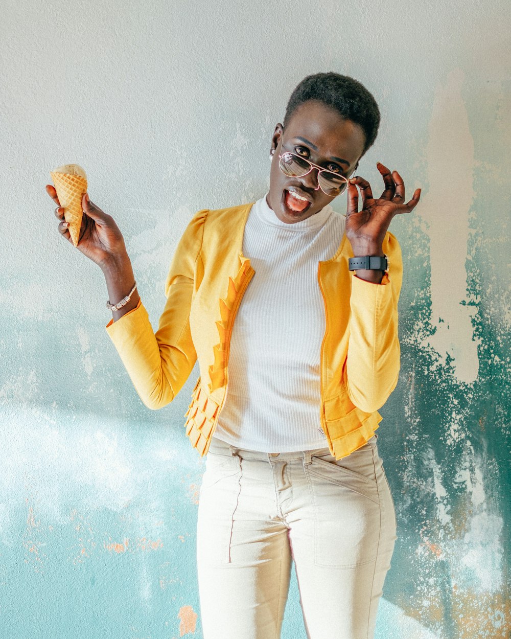 woman in yellow jacket holding ice cream