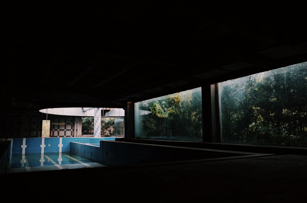 una stanza buia con una piscina nel mezzo di esso