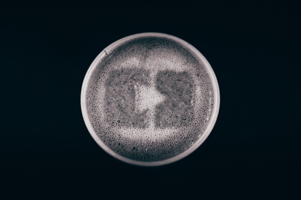 a black and white photo of a beer in a glass