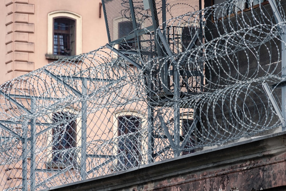 gray barbwire on fence near building during day