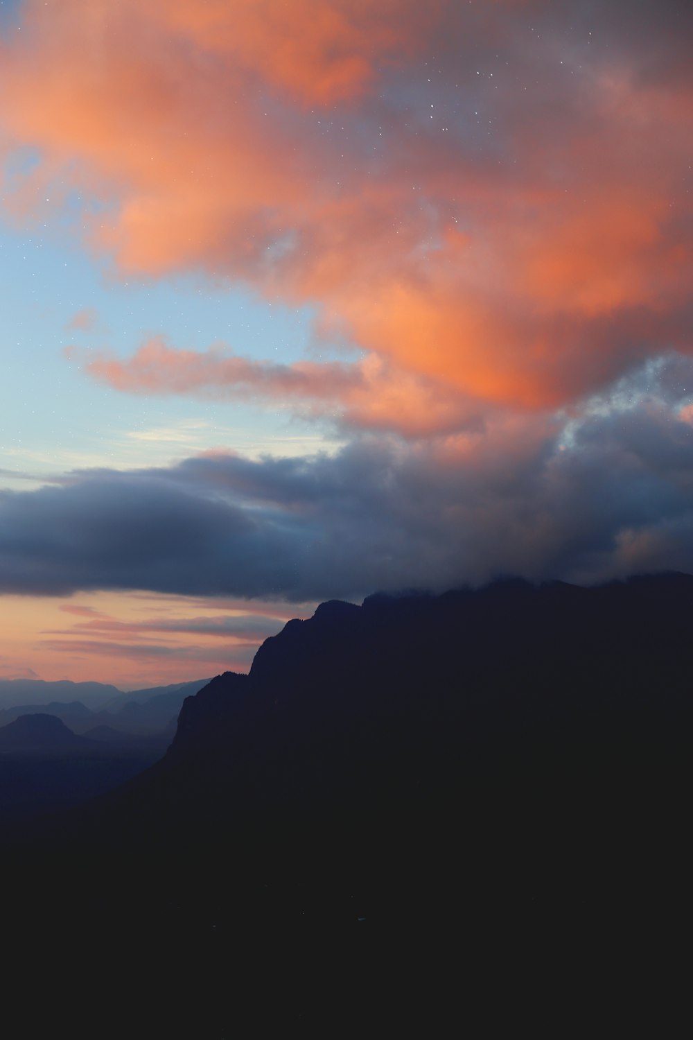 silhueta da montanha sob nuvens