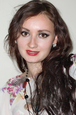 A smiling woman wearing a bold statement necklace and matching earrings at a party.