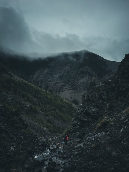 man walking on rocky mountain in Castle Wildland Provincial Park Canada