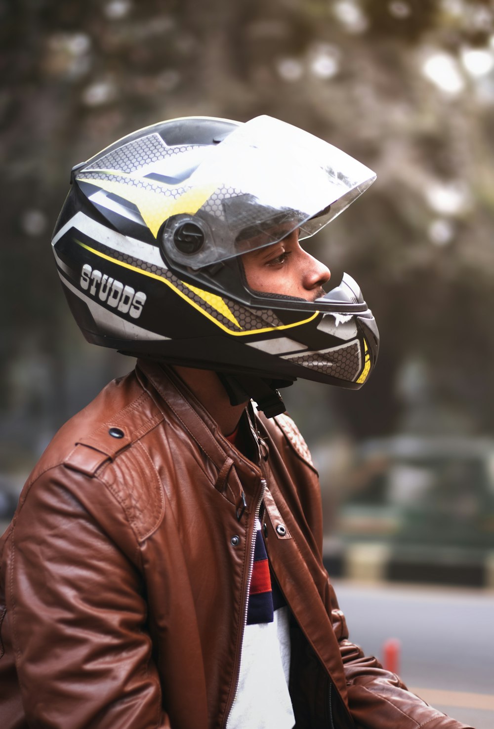 man wearing brown zip-up jacket and black full-face helmet