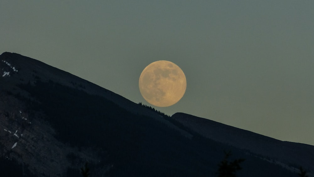 silhueta das montanhas com fundo da lua