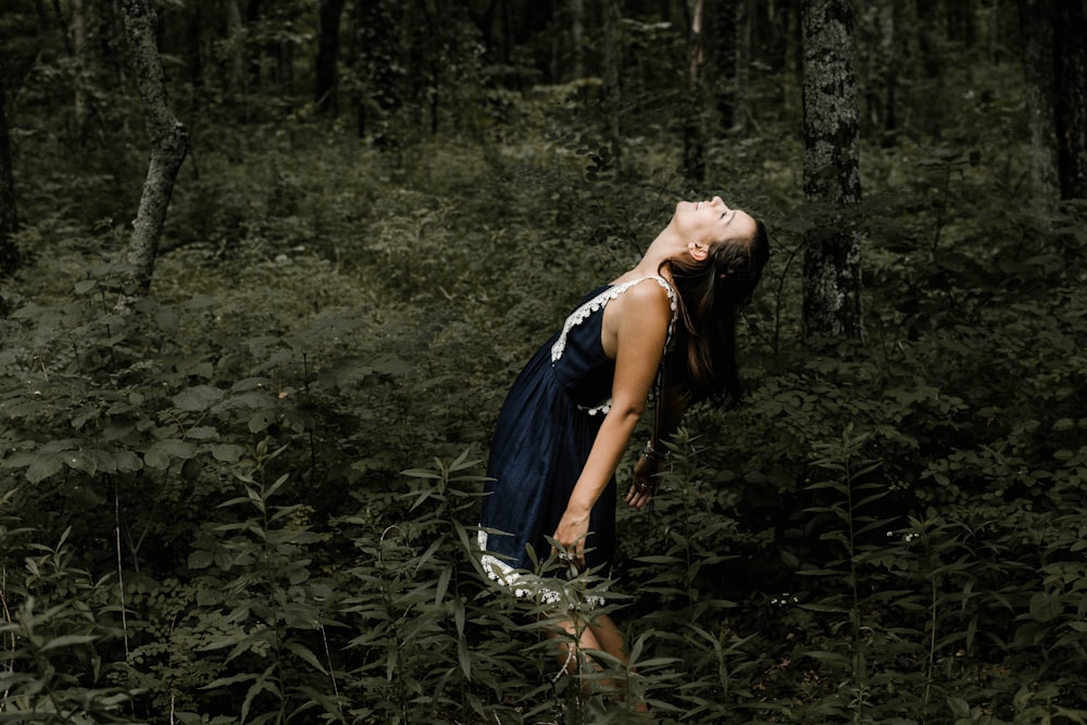 woman standing in the middle of the forest