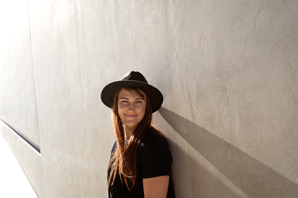 Mujer apoyada en la pared de hormigón gris