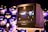 A vintage Sony Trinitron television is placed on a stand, displaying a blurred scene of lights and figures, possibly from a cityscape. The background features multiple reflective spheres, creating an artistic and modern ambiance.