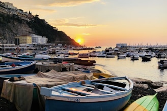 Sunset view of a coastal fishing village with boats docked.