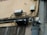 A wall with electrical and telecommunications equipment, including several distribution boxes and a network of intricately arranged cables. A small bird is perched near the top section of the wires.