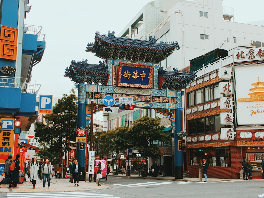 people walking pass blue Chinese gate