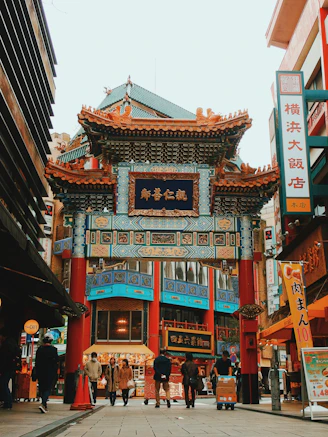 A traditional Chinese gate in Yokohama Chinatown with people walking on the street