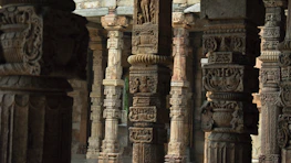 Elegant temple stone pillars arranged neatly, showcasing intricate South Indian carvings.