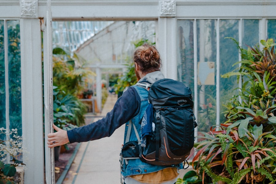 man wearing an osprey backpack walking through a door