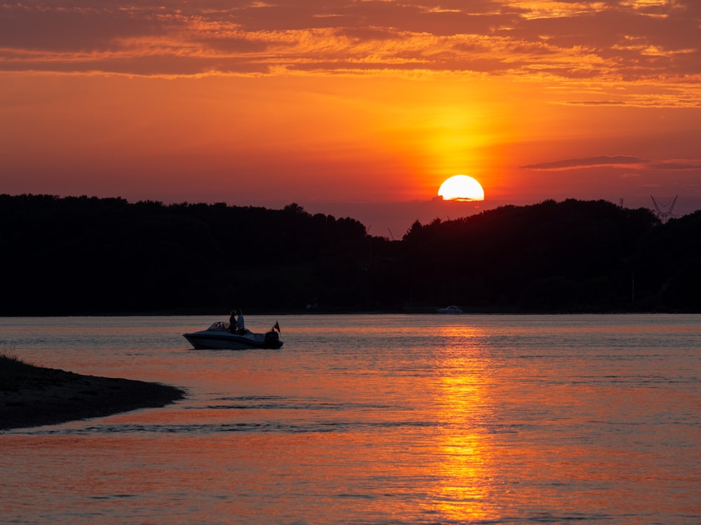 Barca bianca sullo specchio d'acqua durante l'ora d'oro