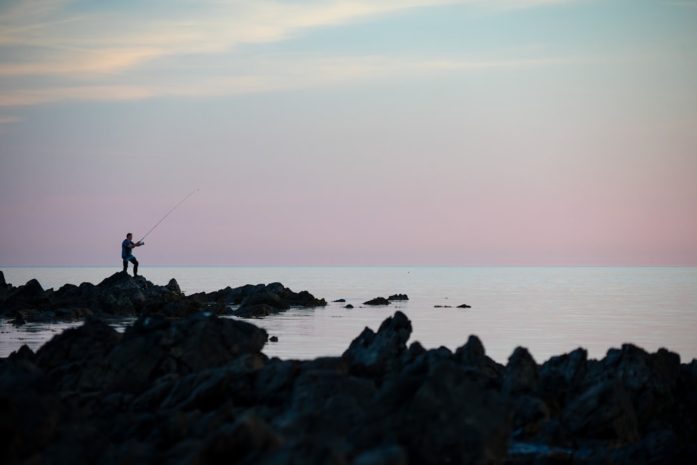 silhouette dell'uomo che pesca sul mare calmo