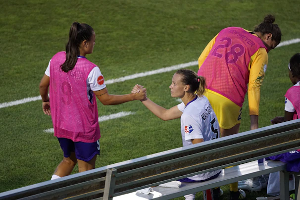 A mentor and mentee sharing a fist bump after a tough game, smiles and respect evident between them.