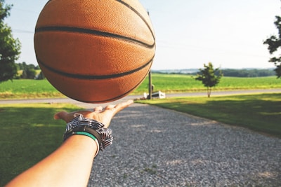 Coach giving hands-on guidance to a student practicing free throws under the bright sky.