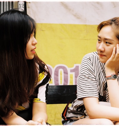 woman in white-and-black striped tops looking each other