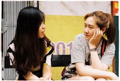 woman in white-and-black striped tops looking each other