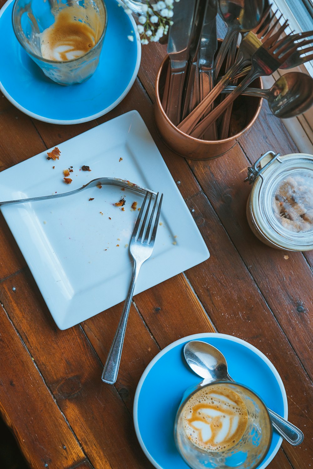 Forchetta e cucchiaio su piatto quadrato in ceramica bianca