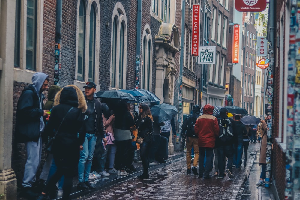 group of people on sidewalk with umbrella