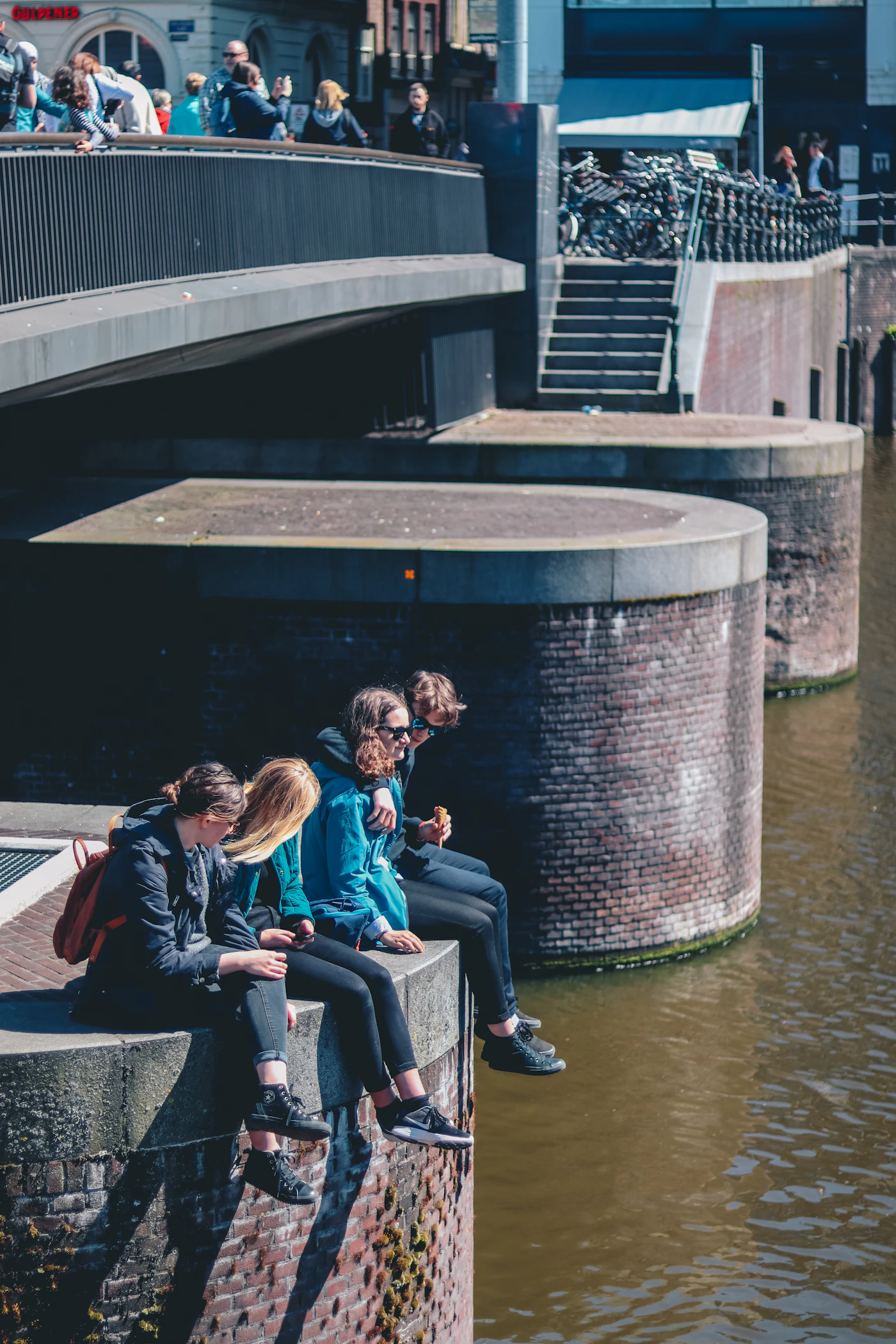 Vrienden zitten samen bij een brug aan het water